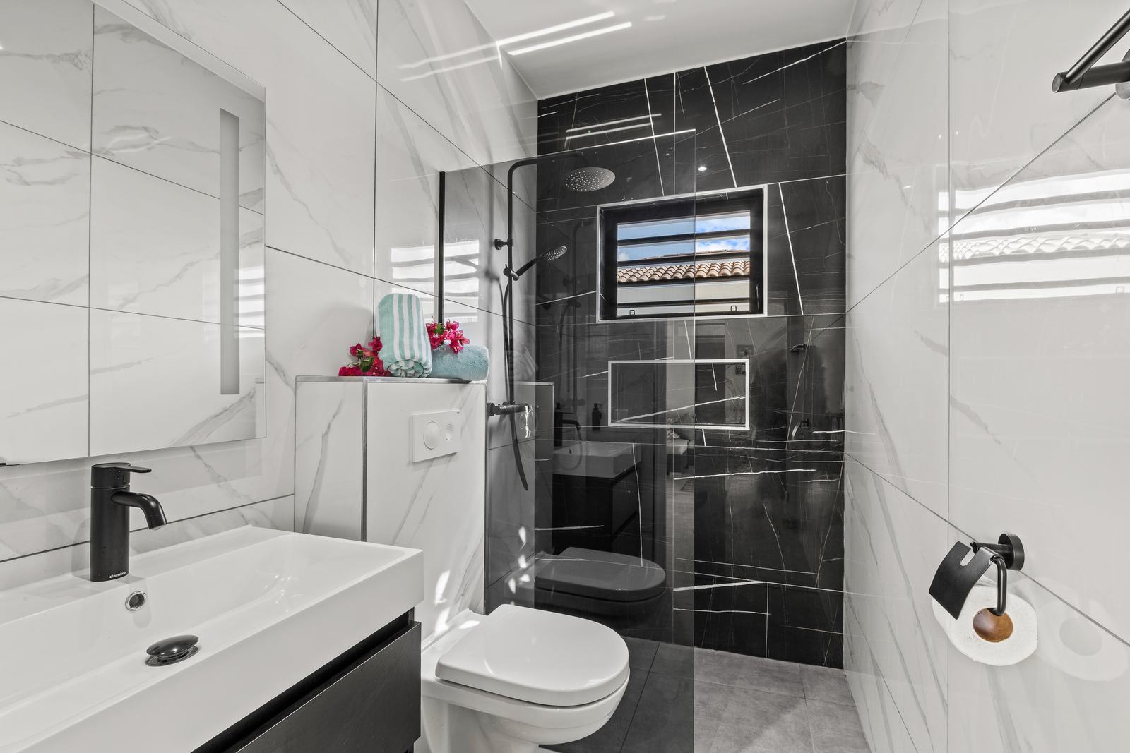 Bathroom with walk-in shower and black marble detailing