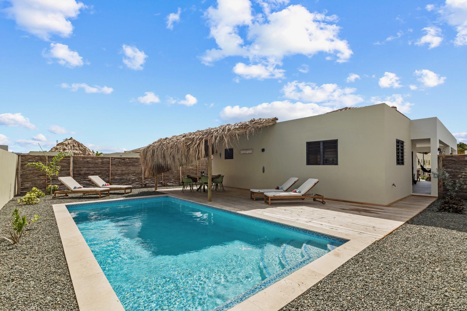Priv&eacute;zwembad van Villa Mambolicious met palapa en ligbedden